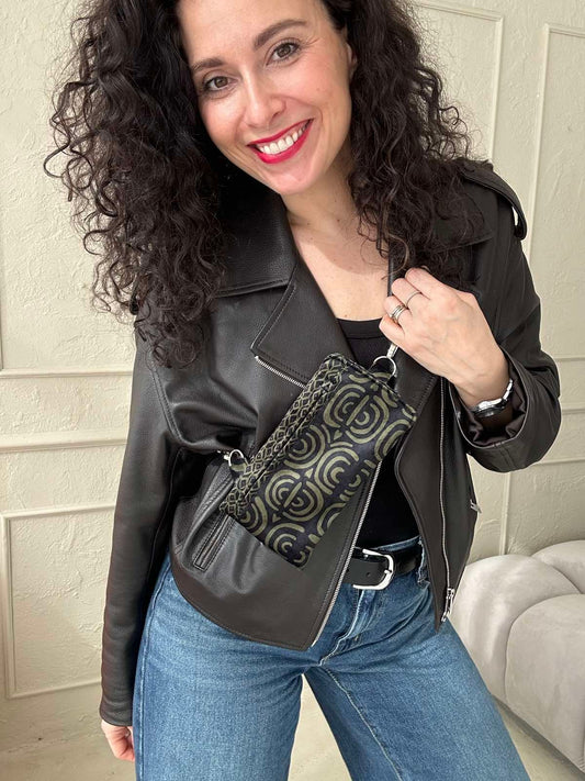 Käsintehty puhelinlaukku, jossa on kuvioitu khakin sävyinen kuosi sekä säädettävä hihna. Laukkuun mahtuu puhelin, passi ja useita kortteja.