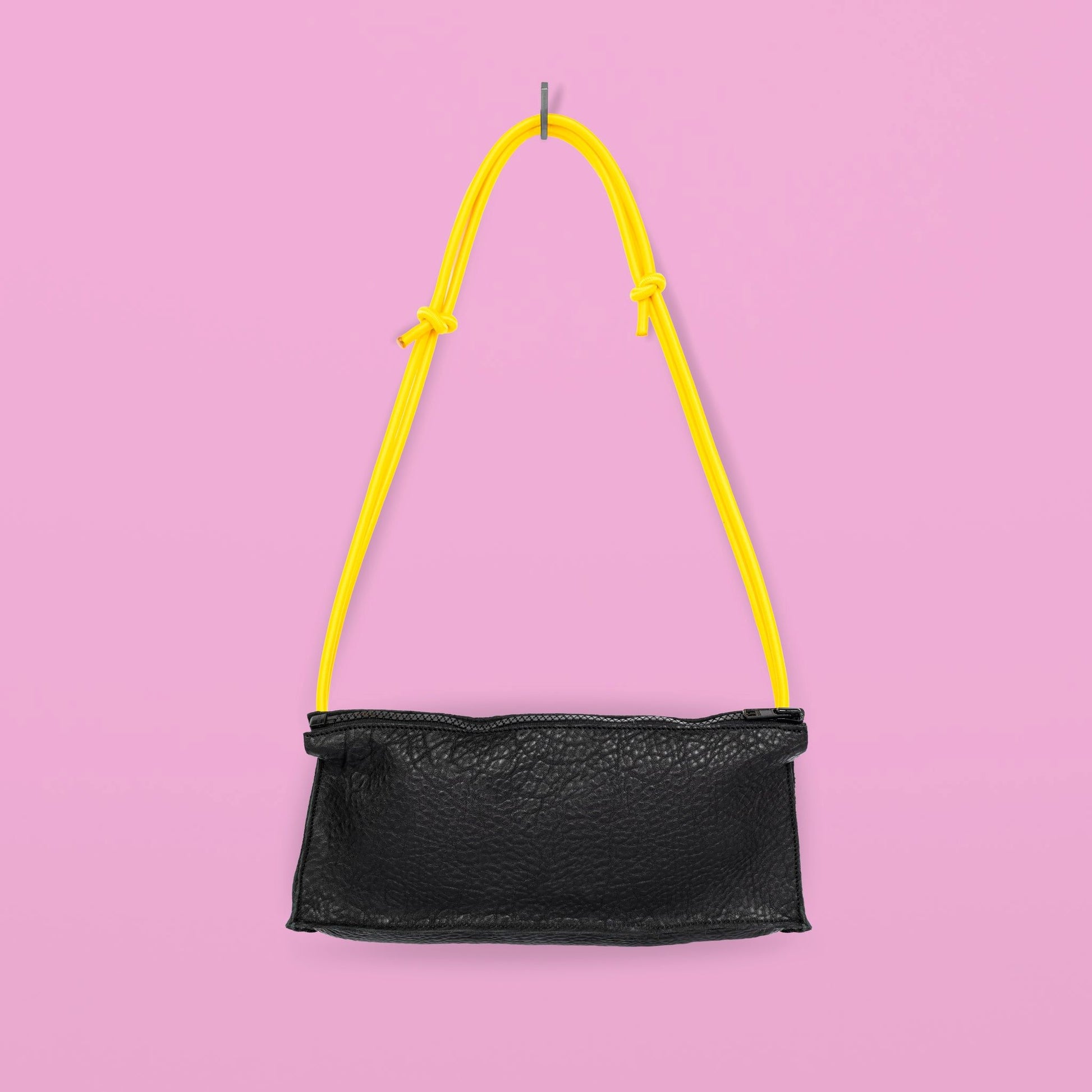 Daz Studion käsintehty crossbody-laukku, joka on valmistettu mustasta aidosta nahasta. Keltainen olkahihna säädettävä ja elastinen.