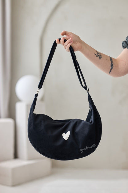 Musta Garbanota -tuotemerkin Hobo-olkalaukku, joka on valmistettu pehmeästä ja kestävästä veluurista. Garbanota -kuvioinen vuori, kaksi sisätaskua ja säädettävä olkahihna.