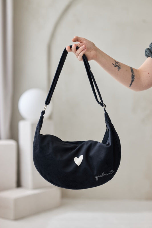 Musta Garbanota -tuotemerkin Hobo-olkalaukku, joka on valmistettu pehmeästä ja kestävästä veluurista. Garbanota -kuvioinen vuori, kaksi sisätaskua ja säädettävä olkahihna.